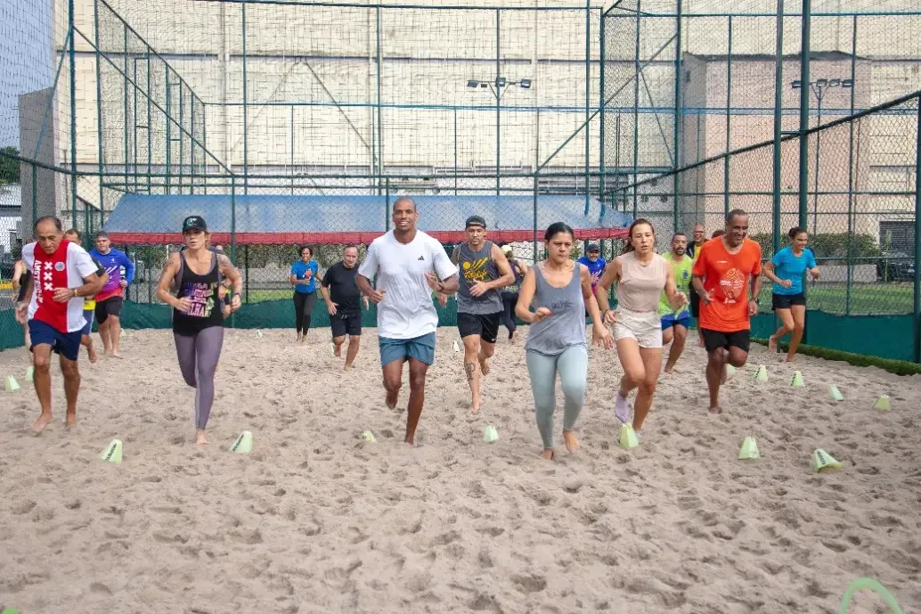 Turma de treino funcional correndo na quadra de areia da FitsLife